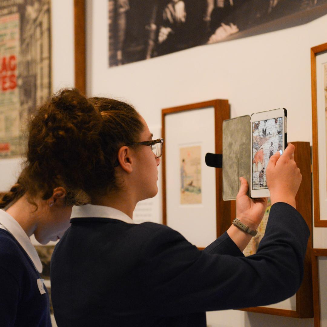 Student scanning a picture on wall with her tablet