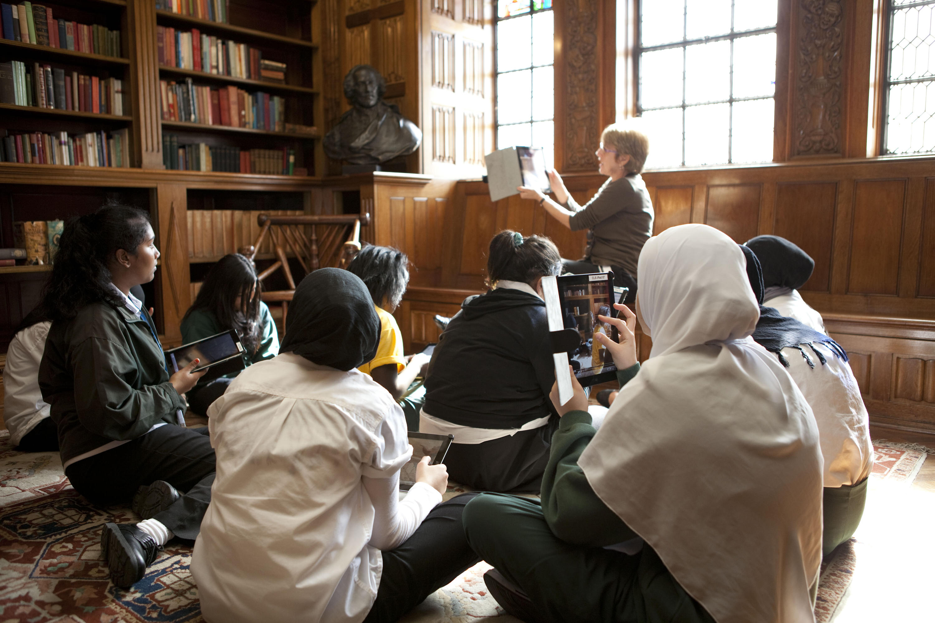 Students sitting in the State Library Shakespeare Room looking at iPads