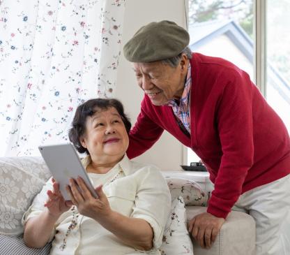 Older couple using an iPad and smiling